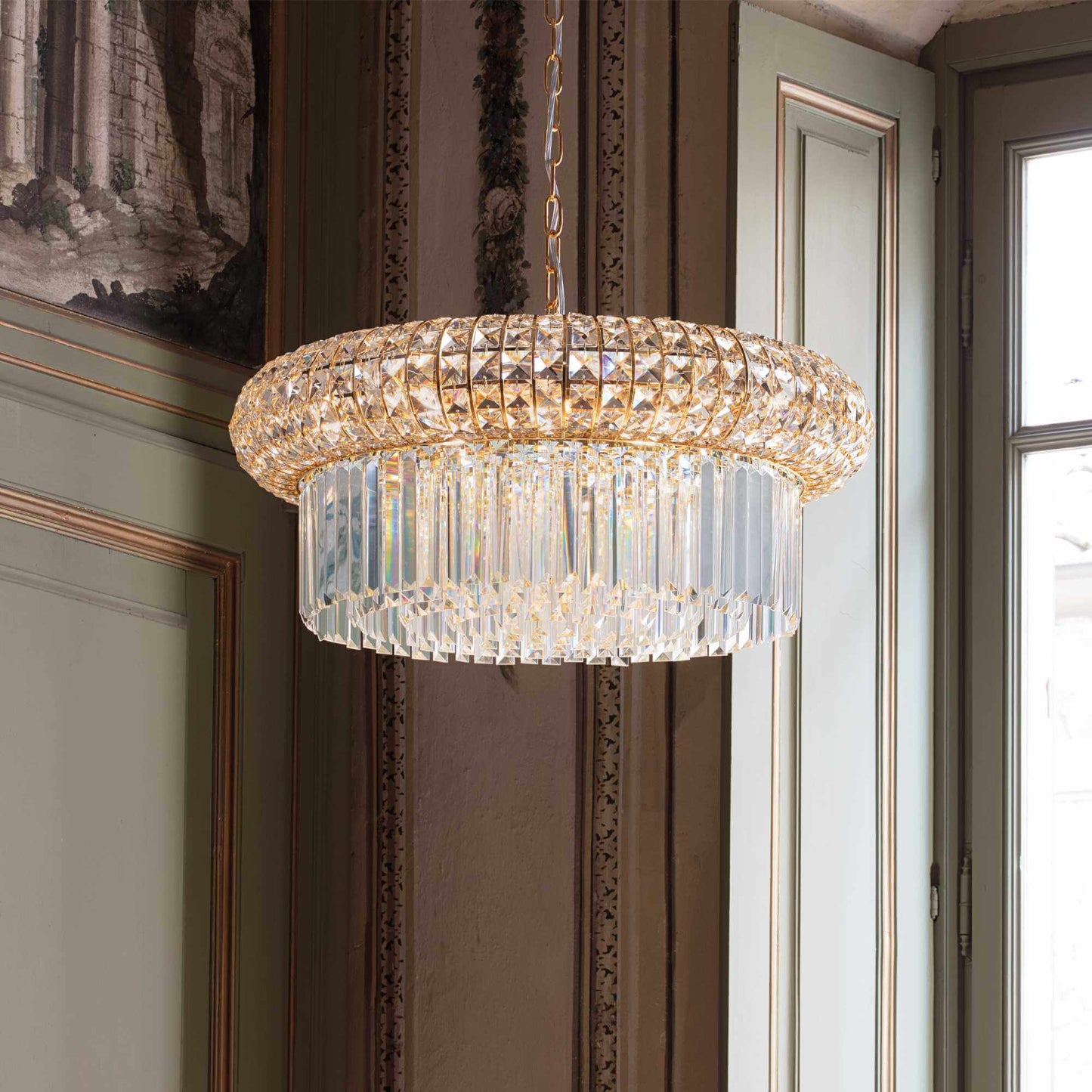 Drum shaped golden chandelier with square and round crystals in the corner of a living room